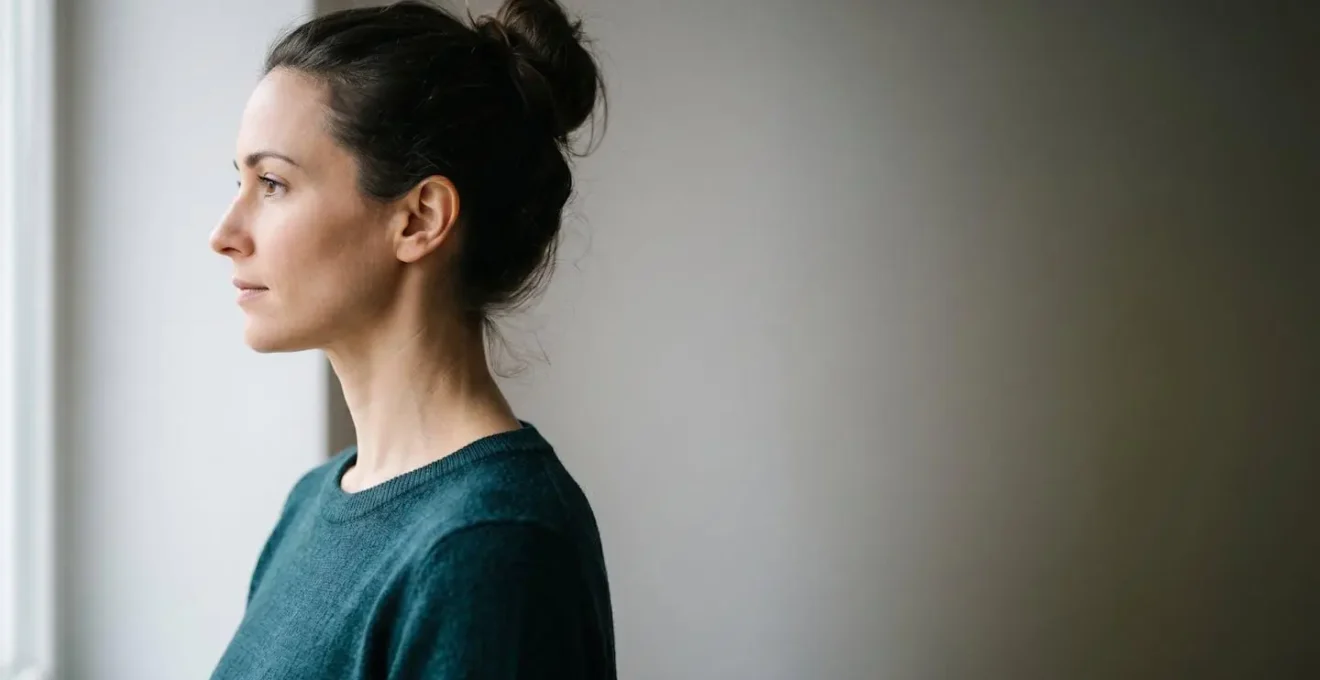 Side profile view of a person demonstrating proper neck alignment and chin tuck position in soft natural lighting with emphasis on cervical spine posture