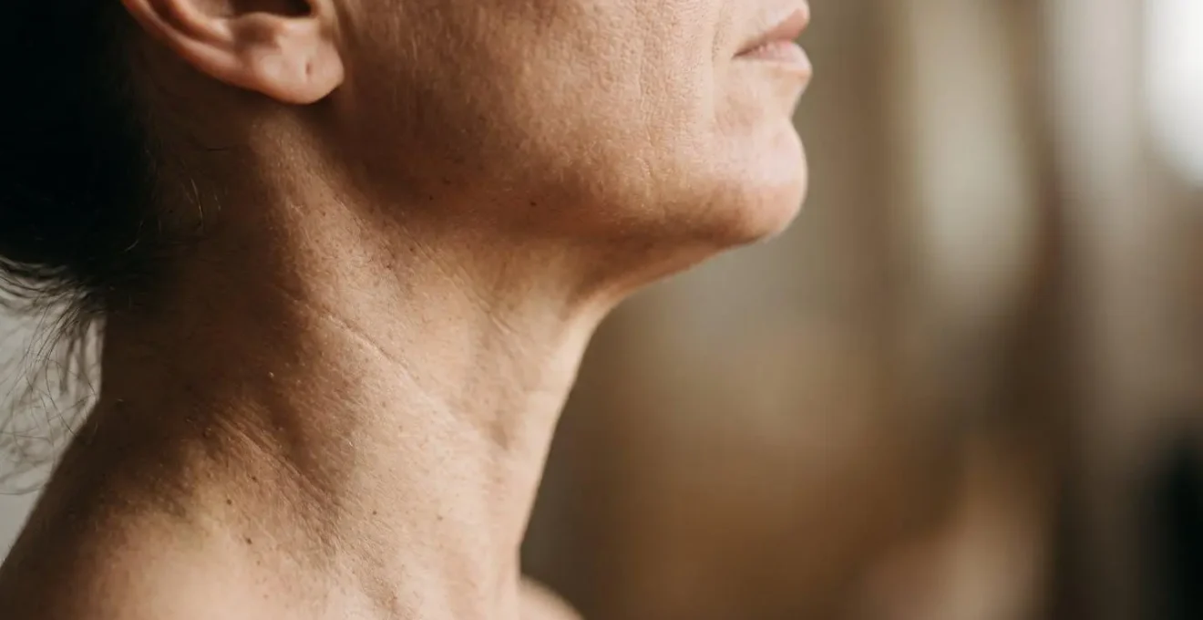 Close-up editorial photograph demonstrating proper chin tuck technique with focus on cervical alignment