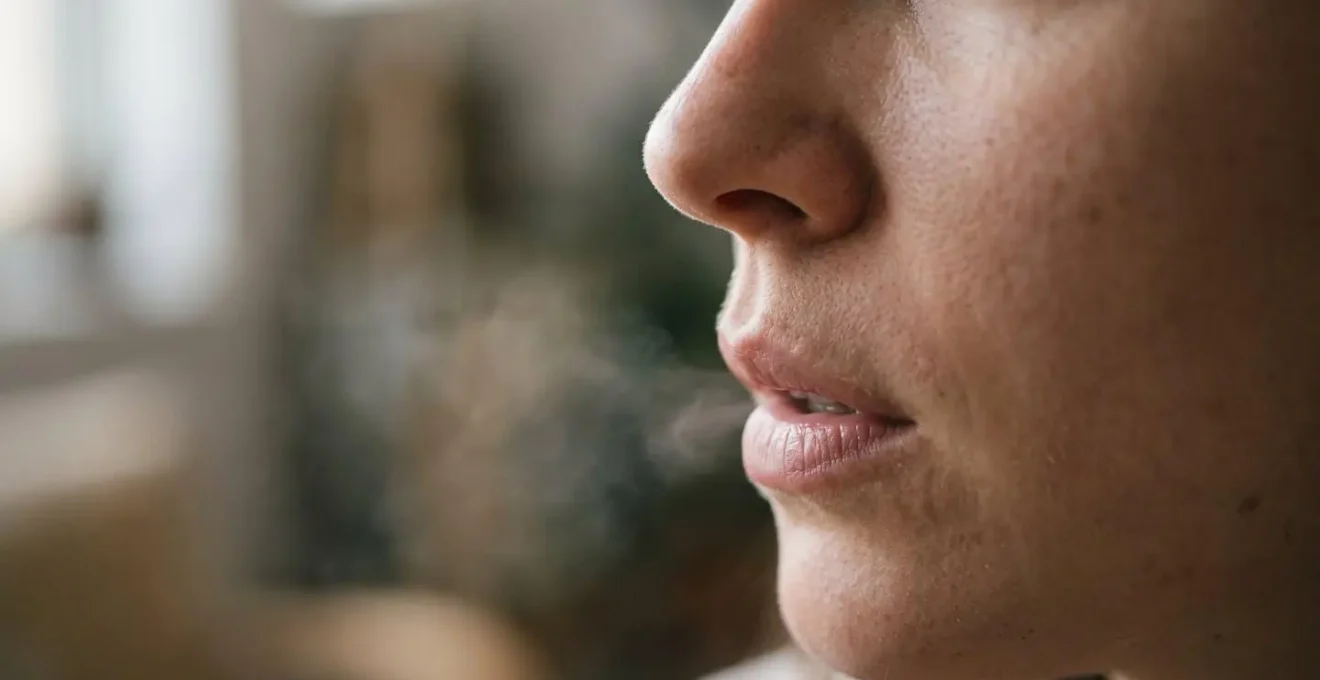 Extreme close-up of person's profile performing double-inhale breathing technique with visible calm expression